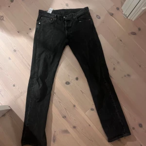 Svarta Levis 501 jeans - Säljer ett par klassiska svarta Levis 501 jeans i storlek W32 L34. De är i bra skick och har den ikoniska raka passformen. Perfekta för både vardag och fest! 🖤 Det är bara att skriva om du har några frågor eller vill ha fler bilder! 