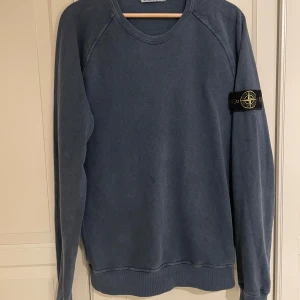 Stone Island crewneck tröja - En (äkta) Stone Island crewneck tröja / sweatshirt i mycket fint skick.  Mörkblå/gråblå.   Storlek Medium.   Väldigt mjuk och skön tröja till hösten.  