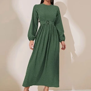 Grön långklänning med prickigt mönster - Säljer en superfin grön långklänning med vita prickar. Klänningen har långa ärmar och en smickrande passform i midjan. Perfekt för både vardag och festliga tillfällen!