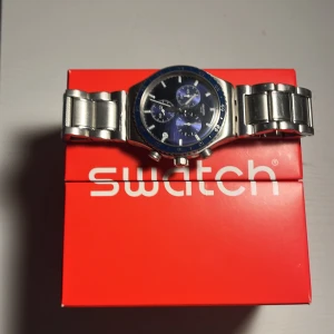 Snygg mörkblå och silver klocka från swatch ny kostar den 2300 jag säljer för 1200 - Bra skick dock med lite repor och inga batteri. Kommer med original lådan och reservdelar 