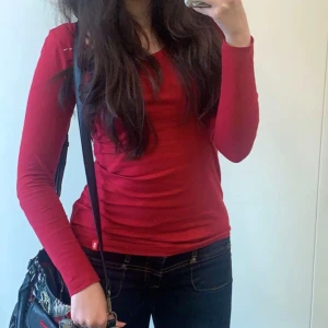 Röd långärmad topp - Säljer en snygg röd långärmad topp i bomull. Perfekt för både vardag och fest! Den har en enkel och stilren design med en rund halsringning. Passar bra till jeans eller kjol för en avslappnad look. ❤️