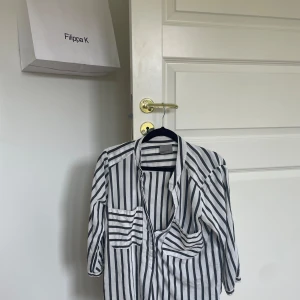 Randig skjorta från Vero Moda - Säljer en snygg randig skjorta från Vero Moda i storlek S. Skjortan har ett klassiskt svartvitt randigt mönster och är långärmad. Perfekt för både vardag och fest! 🖤🤍
