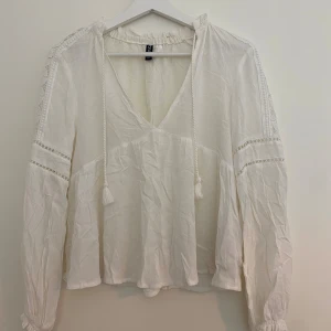 Söt blus  - Jag säljer en blus i jättefint skick! Söta detaljer på ärmarna och tofsar man kan knyta det fram😍Storlek 34
