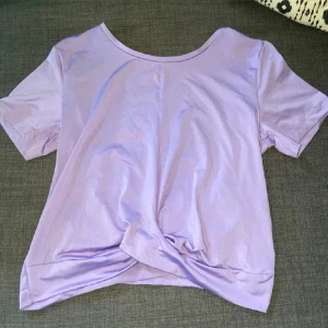 Ljuslila t-shirt från H&M Move - Säljer en ljuslila t-shirt från H&M Move. Den är i ett mjukt-lent bekvämt bomullsmaterial, perfekt för vardagsbruk och träning. T-shirten har en rund halsringning och korta ärmar. Den är i bra skick och redo för en ny ägare!