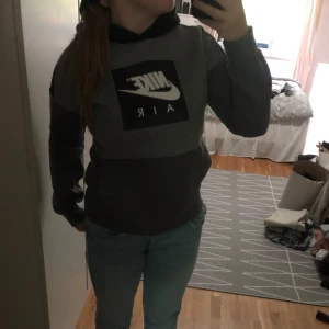 Grå och svart hoodie från Nike - Säljer en snygg och bekväm grå och svart hoodie från Nike Air. Är i barn-storlek L men skulle säga att den passar en XS