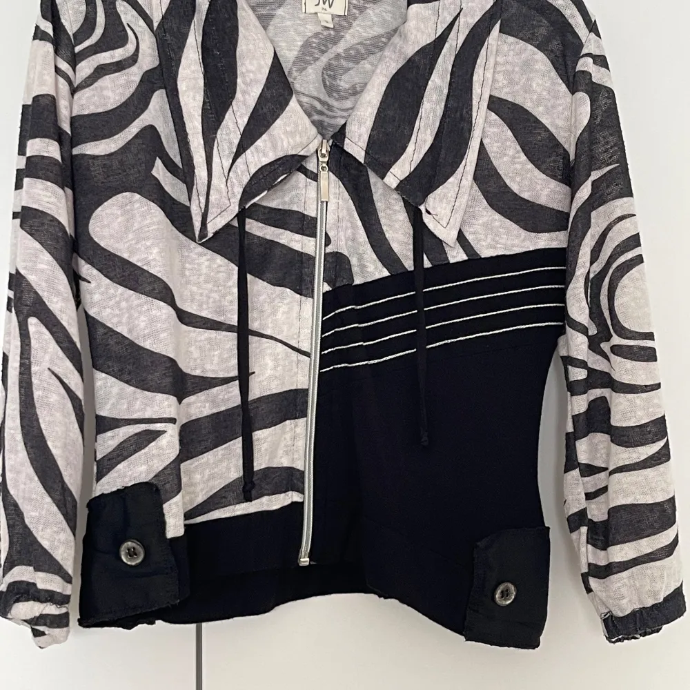 Säljer en unik zebramönstrad jacka från JW. Den har en cool dragkedja framtill och en snygg krage. Tunn jacka/”cardigan” är långärmad och har en kontrasterande svart del med vita linjer på framsidan. Perfekt för att sticka ut i mängden!. Takit.