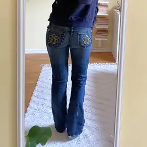 Jeansen är bootcut och lågmidjade, trycket på fickorna är guldigt. Har en extra söm längst ned (kan skicka bild) och en reva under fickan (sista bilden), är annars i fint skick. Hör av dig om du är intresserad💞 Innerbenslängd: 78cm, midjemått: 39cm