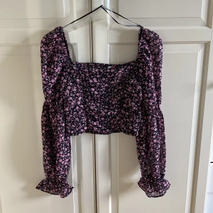 Blommig topp från H&M  - Säljer denna söta croppad toppen från H&M. I fint skick. Storlek 36. Scrunch på framsidan. Nästan som off-shoulder. Blommig. 100% polyester.
