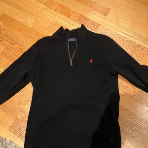 Ralph lauren halfzip - Svart Ralph lauren halfzip tröja med röd logga, tröjan är knappt använd och storlek L. Passar mig perfekt som är 186m och 73kg