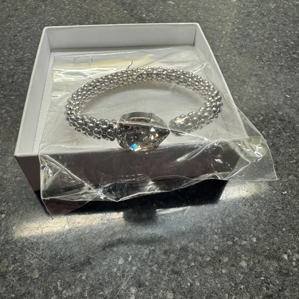 Ett helt nytt Caroline Svedbom armband i silver med vit kristall. Helt oanvänd och ligger oöppnad i sin förpackning. Medföljer smyckesbox. Inga som helst defekter på smyckesboxen. Köpt för 995kr. Accessoarer.