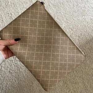 By Malene Birger väska  - Säljer en Beige väska ifrån By malene birger. Defekt finns på axelremmen, men funkar att använda.