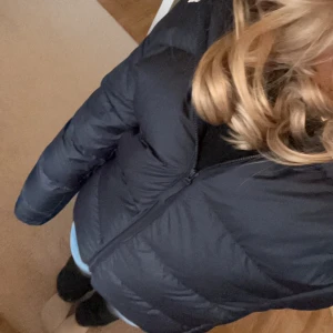 Jacka från adidas  - Säljer jättefin mörkblå/svart vinterjacka från adidas. Den har 3 vita streck på ärmarna som sträcker sig ungefär från axeln till en bit över armbågen (glömde fota dessa men kan ta bild vid önskemål). Passar mig som brukar ha xs/s. 