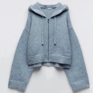 Grå stickad hoodie - Säljer en supermysig grå stickad hoodie med dragkedja och huva. Den har en croppad passform och ribbade muddar vid ärmslut och nederkant. Perfekt för kyliga dagar när du vill vara både bekväm och stilren. 🩶