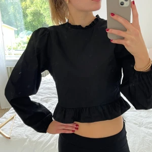 Svart volang topp med tight midja - Så söt topp. Använd en gång. Dold dragkedja i midjan. 