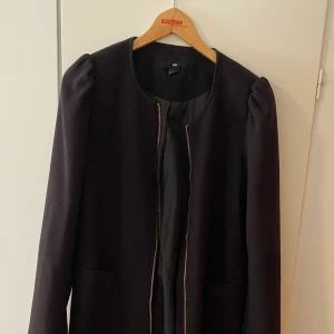 En svart kappa från H&M - En svart kappa fått ifrån morsan som inte kommer till användning längre, använt ett fåtal gånger. Storleken på kappan står det ska vara 42 men det tycker jag inte stämmer in utan även jag som brukar bära M tycker den känns som M Max L. 