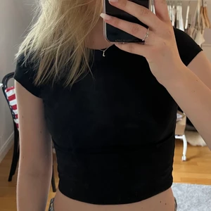 Svart croppad t-shirt - Säljer denna svarta croppade t-shirten från Nly trend💗I strl S. Köparen står för frakten💗