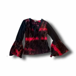 Topp - Topp med utsvängda ärmar och urringning. Den har mönster i sammet samt detaljer i spets. En väldigt älskad topp som sitter väldigt smickrande på! 