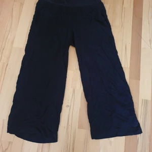 Supersköna svarta byxor med mudd upptill - Supersköna tunna svarta byxor med mudd upptill. I fint skick. Stl S