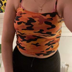 Fint croppat linne med orange camouflage. 