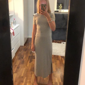 Ribbad lång klänning med slits - Aldrig använd. Ribbad grå långklänning. Är lite för kort. Men jättefin. Väldigt lyxig matirial. Får 10/10 av mig. Puss o kram😘