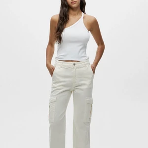 Vita cargo byxor pull and bear  - Slutsålda vita/gräddvita cargo byxor från pull and bear, använda 1 gång, storlek 36