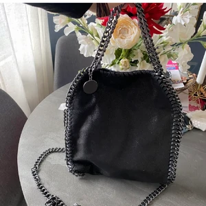 Svart väska 💕 - Stella Mcartney likande väska i bra skick, knappen på insidan som stänger väskan är trasig annars är väskan i topp skick 😍 Bud: 500kr plus frakt