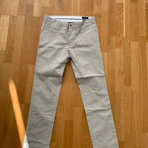 Ralph lauren byxor - Säljer ett par Ralph lauren byxor/chinos helt oanvända med lapp kvar. Storlek 33/32 (slimfit). Pris kan diskuteras! Nypris:1500