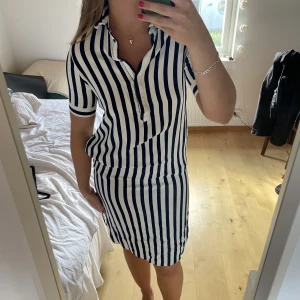 Randig klänning - Härlig sommarklänning i en marinblå och vit rand. Köpt på Veromoda samt använd fåtal gånger. Har fickor på båda sidorna samt slits. Hör av dig vid frågor💕