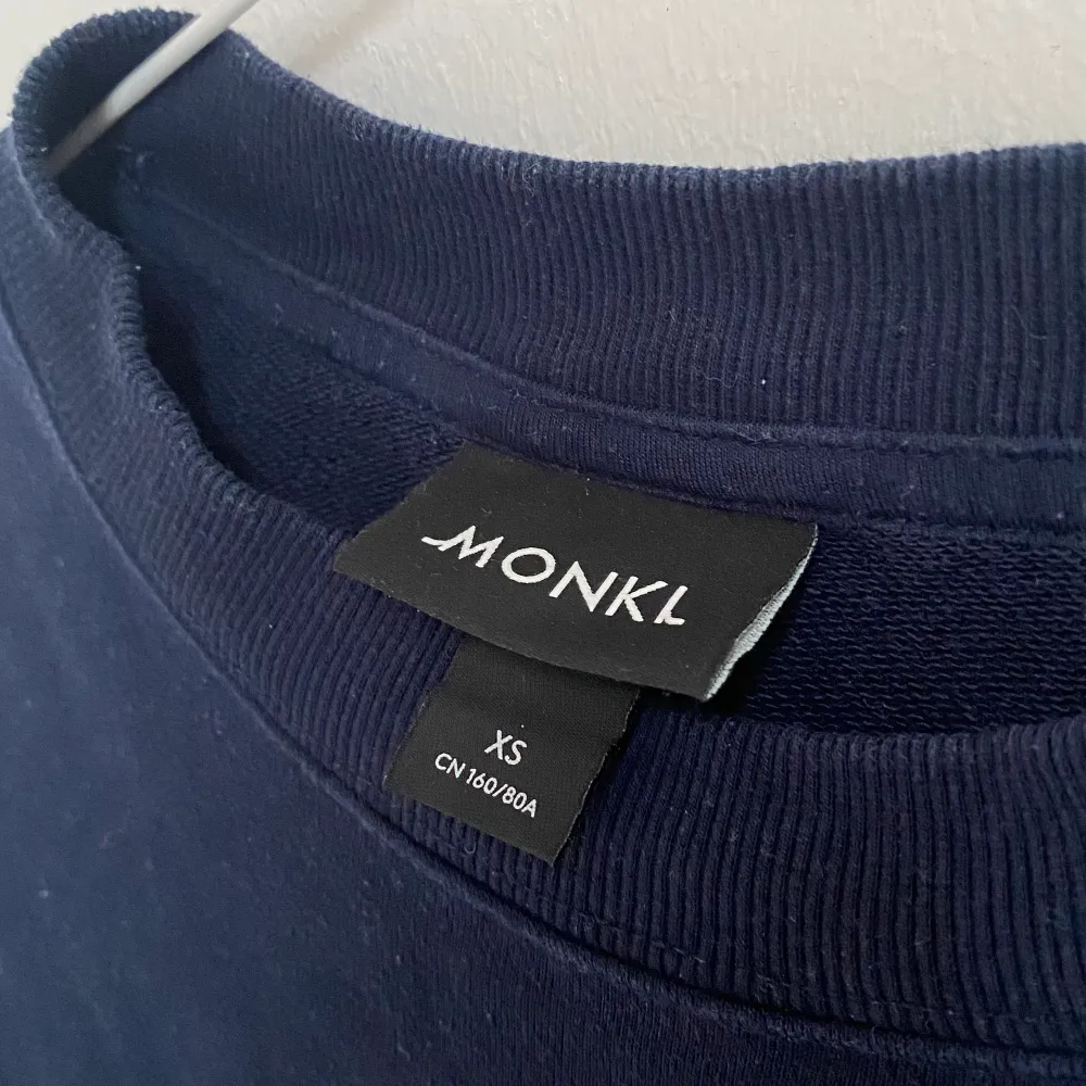 Marinblå sweatshirt från monki i stl xs. Broderad text på framsidan. . Hoodies.