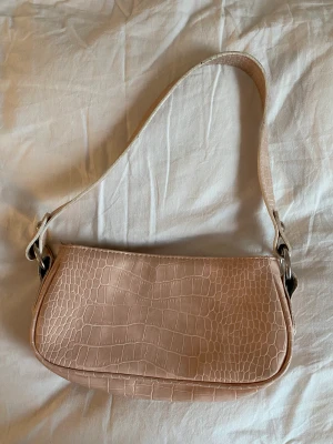 Väska  - Fin baguette väska från ASOS! Färgen är i dusty pink (alltså ej smutsig). Stängs med dragkedja ❤️