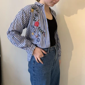 Randig broderad skjorta  - Randig skjorta med broderade blommor 🌷. Från Zara Girls, men passar även S/M.  Nypris: 300 kr Oanvänd. 