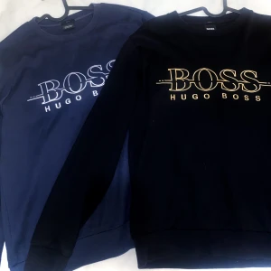 2 Hugo boss tröjor  - En svart/guld hugo boss tröja och en blå/silver hugo boss trjöa. Båda tröjorna är äkta och i bra material. Används 2-3 gånger. 650kr per styck.