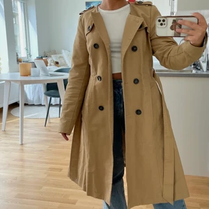 Trenchcoat - Superfin trenchcoat från Lindex i strl 38 o fint begagnat skick 💌 Den har e  liten fläck på vänster sida (syns på bild 3). Fraktas spårbart för 66 kr!