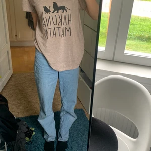 Overzised hakona matata T-shirt  - En overzised T-shirt med ett tryck av hakuna matata från lejonkungen. Den har ett v format krage och ett mjukt tyg. 