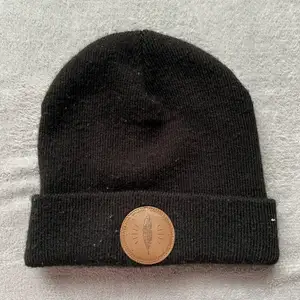 svart beanie med brun detalj, ganska använd men bra skick tror jag köpte den på intersport