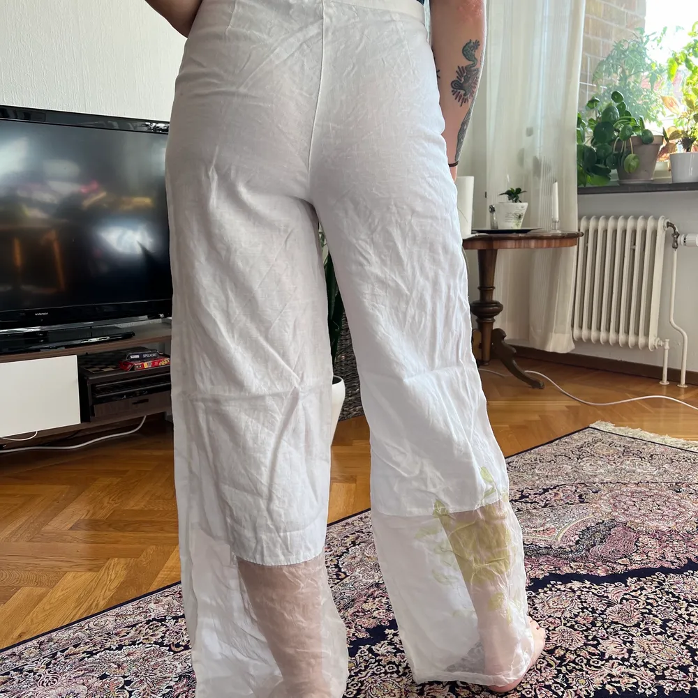 Linnebyxor, på undersidan av byxbenet är det mer transparent tyg med blom-tryck . Jeans & Byxor.