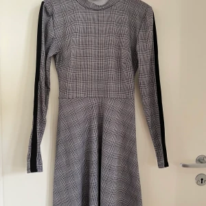 Rutig klänning  - Rutig klänning med långa armar. Obs hund finns i hemmet.