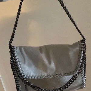 Stella mccartney liknande väska - Säljer stella mccartney inspererande väska💕 Köpt här på plick! Säljes då den inte riktig är min stil! Inga defekter och skickar gärna mer bilder om det önskas! Köparen betalar frakten (spårbar 66kr) eller möts upp nära Lidköping!✨ Man kan ha både kort och långt band!