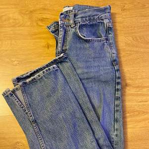 Jag säljer dessa blåa jeans med slits nertill vid foten. De är midwaist och sitter super fint. De är även långa i benen.