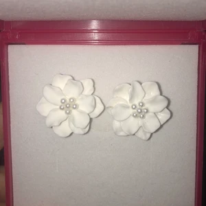 ÖRHÄNGEN VIT BLOMMA - Somriga örhängen i form av en blomma med mindre pärlor inuti. Frakt kostar 14kr inte 29. Samfraktar. Filmar/fotar när paketet packas och lämnas till ombud/brevlåda