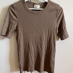 En brun ribbad t shirt från Gina Tricot i storlek M, helt oanvänd❣️