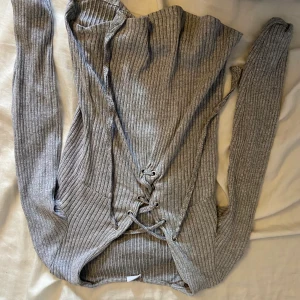 Tröja från Gina tricot  - En ribbad grå tröja från Gina tricot i stl S med snörning. Köparen står för frakt och betalning sker via Swish 🤗  vet ej varför bilderna blir upp och ned så jag ber om ursäkt 🤗