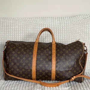 Louis Vuitton Keepall 55 bandouliere  - En Keepall bandouliere 55 från Louis Vuitton i mycket fint skick!  Mycket fin canvas utan skador och slitningar. Bandet är original och har inte använts många gånger, är i nyskick! Fin och fräsch insida. mycket gott skick utan skador.   Datecode: VI0940  