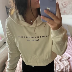 Beige hoodie med tryck - Beige hoodie med luva och text från Gina tricot. I midjan finns snörning som kan användas för en croppad passform. Använd få gånger och i fint skick. xxs. Köparen står för frakt.