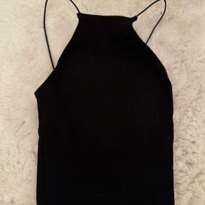 Topp - En svart kortare topp från zara. Med tunna runda snören och ribbat material. I storlek xs/s