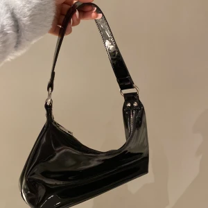 Lackväska från Ginatricot - En lackväska från Gina, bra skick förutom en liten skada, har bra plats och är den perfekta axelväska💗💗 sänker såklart priset på dem pågrund av den lilla skadan💓💓