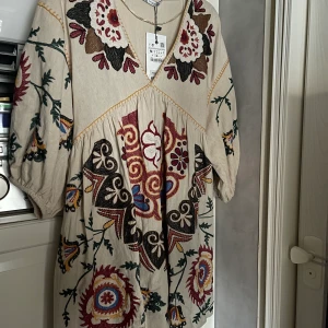 Klänning från zara - Fin klänning från zara med brodyr. Aldrig använd prislapp finns kvar. Stl M Färg: naturvit/beige