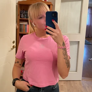 Adidas t-shirt storlek S - Cropped rosa, oanvänd t-shirt. Snygg detalj fram på bröstet. Bara legat i garderoben utan att komma till användning! 💕