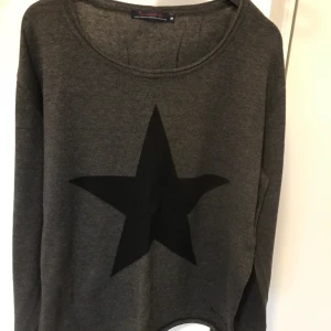 Bondelid stickad tröja  - Mörkgrå fin stickad tröja från Bondelid med svart stjärna fram. Mjuk och skön. Frakt betalas av köparen.