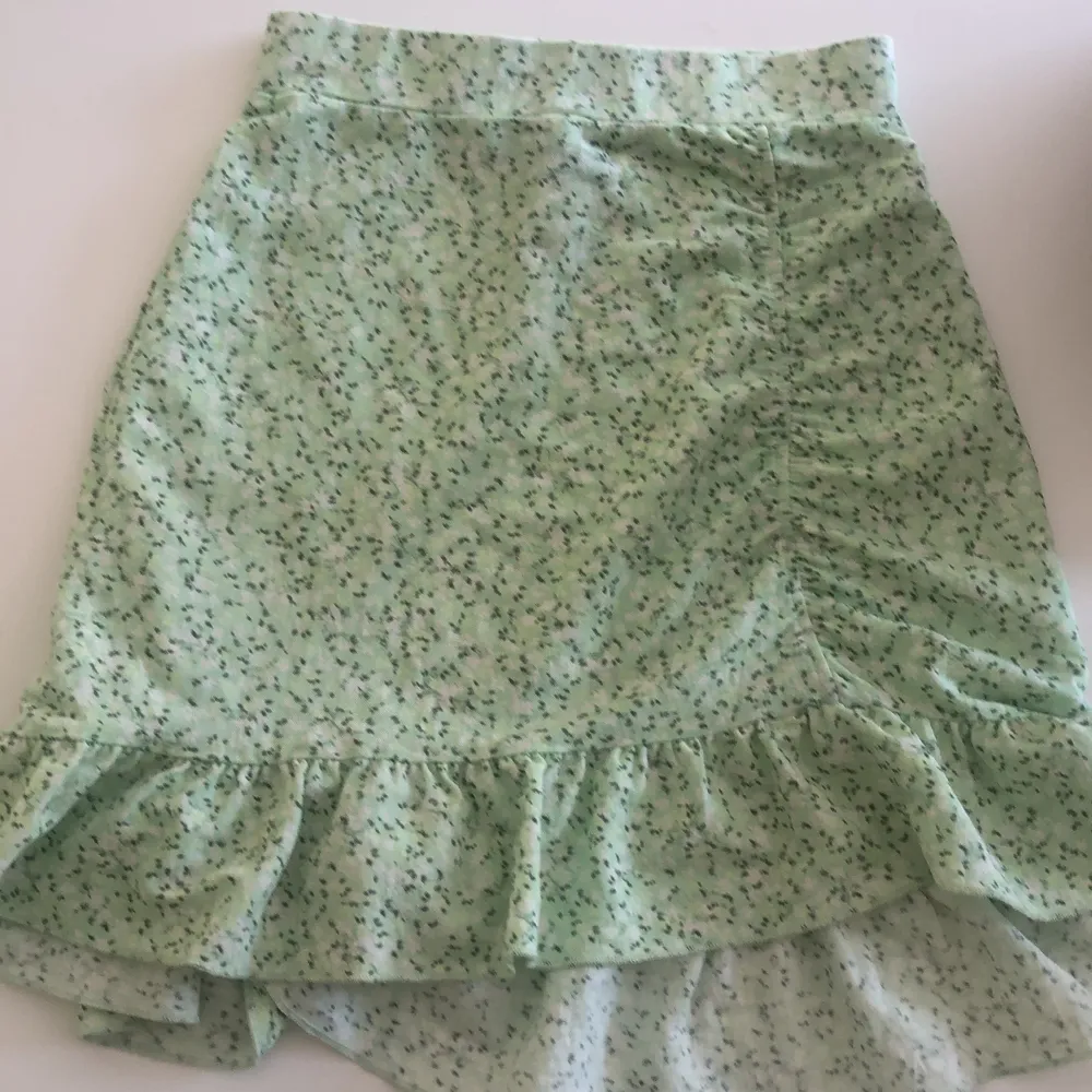 En fin grön blommig kjol med en liten scrunch. Säljer för att den är lite för tajt. Kjolar.